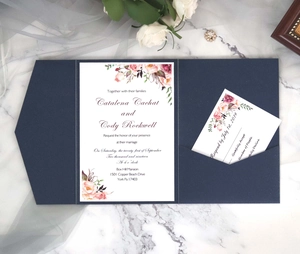 Flat lay of navy blue floral wedding invitation set with RSVP card on marble background
