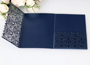 Detail of navy blue laser cut wedding invitation with elegant floral lace pattern