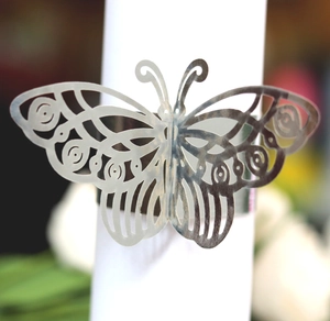 Detailed close-up of golden laser-cut butterfly napkin ring with hollowed wing texture