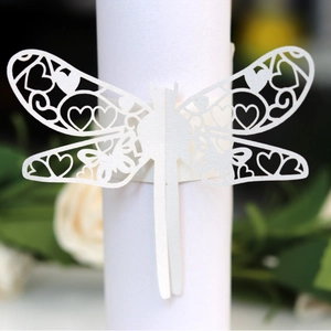 Elegant white dragonfly laser-cut paper napkin ring with hollow heart patterns for weddings