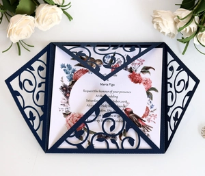 Detailed laser-cut vine patterns on navy blue pearl paper wedding invitation set