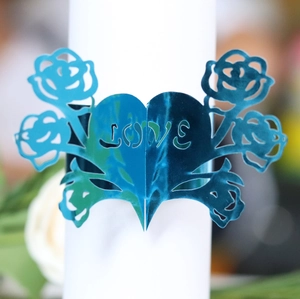 Close-up of metallic blue laser-cut heart and rose paper napkin ring with LOVE cutout