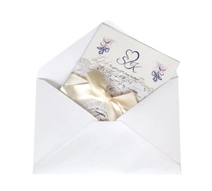 Detail of laser-cut wedding invitation with cream ribbon and floral S&K monogram pattern