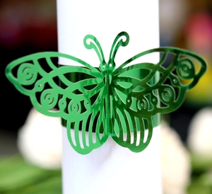 Close-up of laser-cut green butterfly napkin ring with intricate hollow patterns