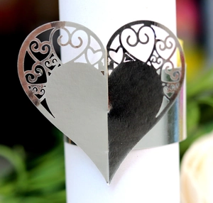 Macro shot of silver heart-shaped napkin ring with detailed laser-cut hollow patterns