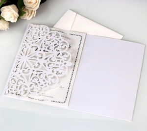 Detailed laser-cut hollow floral design on white wedding invitation suite with roses