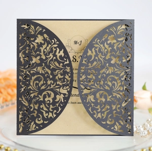 Close-up of laser-cut wedding invitation with intricate floral vine hollow patterns