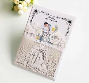 Detail of laser-cut white wedding invitation with elegant horse carriage and rose motifs