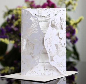 Elegant white laser-cut floral wedding invitation card set with intricate hollowed patterns