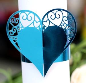 Close-up of heart-shaped laser-cut blue napkin ring with elegant scroll patterns