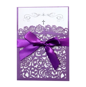 Détails de roses découpées au laser sur invitation violette avec un nœud en satin