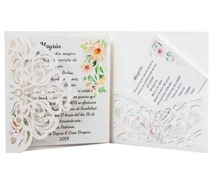 Detail of laser-cut wedding invitation with white lace patterns and floral inner card