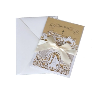 Detail of laser-cut floral wedding invitation with cream ribbon and kraft paper insert