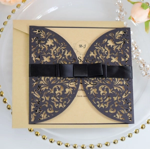 Detail of laser-cut butterfly invitation with dark blue sleeve and satin ribbon