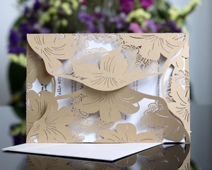 Macro detail of laser-cut lace invitation card with elegant floral pattern and envelope