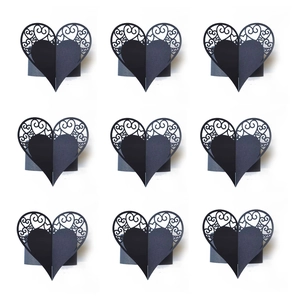 Laser cut black paper napkin rings with hollow vine patterns in a 3x3 grid display