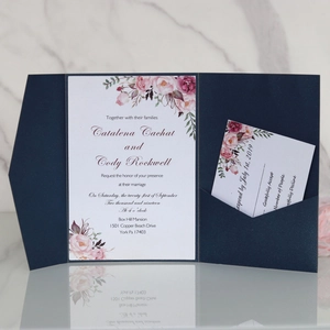 Navy blue pearl laser-cut wedding invitation set with floral inserts on marble