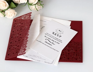 Detail of dark red laser-cut lace wedding invitation suite with white RSVP inserts