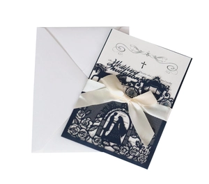 Detailed laser cut wedding invitation set with navy sleeve, ribbon, and insert card