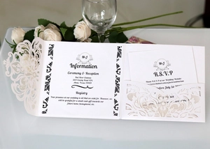 Detailed laser-cut ivory wedding invitation set with elegant floral vine hollow pattern