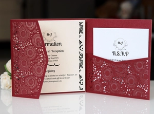 Detail view of laser-cut burgundy wedding invitations with delicate floral lace cover