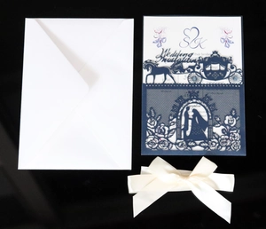 Detailed set of laser-cut wedding invitations with navy blue cover and satin bow