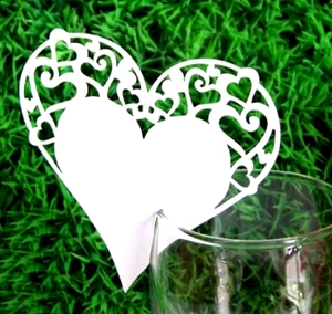 White laser-cut heart glass card with intricate scroll patterns for wedding decor