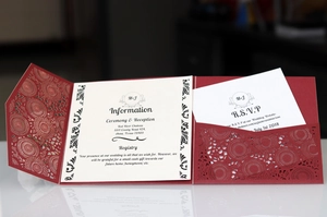 Detail of laser-cut burgundy wedding invitation set with floral patterns and cards