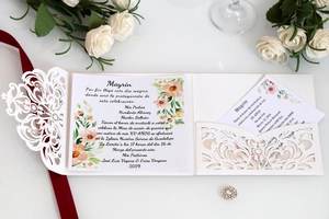 Detail of laser-cut floral wedding invitation set with pearl white cardstock and inserts