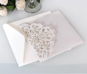 Detailed laser-cut floral pattern on elegant white wedding invitation with pearlescent finish
