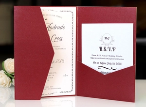 Detail of burgundy laser cut wedding invitation set with RSVP card and white roses