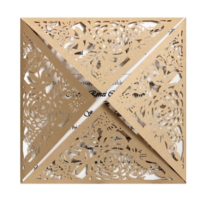 Gros plan sur l'invitation de mariage dorée découpée au laser avec texture papier perlé