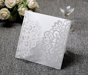 Macro detail of laser-cut wedding invitation cover with elegant white floral patterns