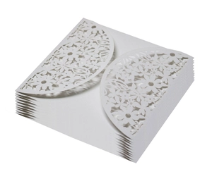 Stack of white laser-cut wedding invitation covers with intricate floral leaf patterns