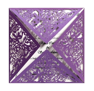 Gros plan d'une invitation de mariage découpée au laser avec roses en violet nacré