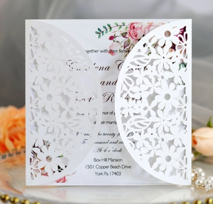 Detailed laser-cut floral wedding invitation with pink rose insert and elegant pearls