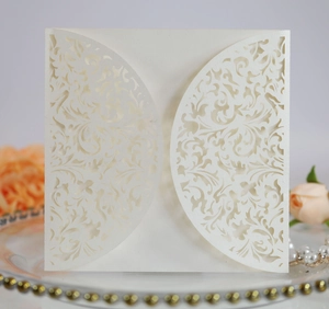 Macro view of laser-cut invitation card with floral scroll patterns and pearlescent paper