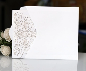 Detailed view of laser-cut mandala wedding invitation with a white envelope