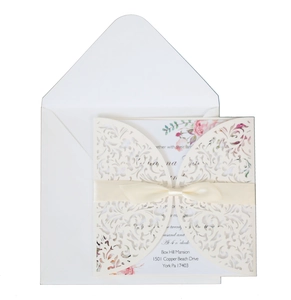 Navy laser-cut wedding invitation with white floral lace cover and silk ribbon bow