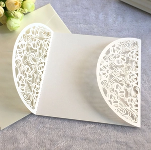 Macro detail of laser-cut white wedding invitation envelope with floral hollow patterns