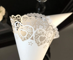 Detail of laser-cut wedding petal cone featuring delicate heart and lace hollow patterns