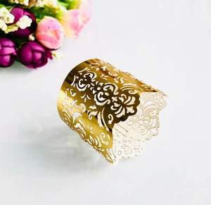 Detailed view of golden laser-cut decorative ring with intricate vine pattern