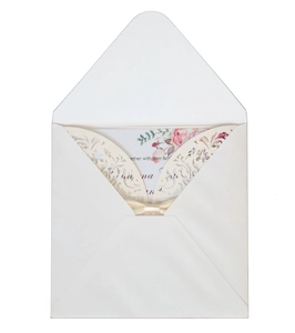 Detail of laser-cut floral invitation cover with ribbon bow and floral inner card