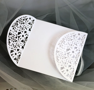 Detail of white laser-cut floral patterns on elegant trifold wedding invitations