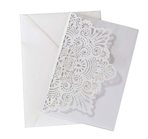 Detail of white laser cut floral wedding invitation card with intricate vine patterns