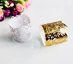 Macro shot of gold and silver laser-cut paper wraps with elegant floral vine patterns