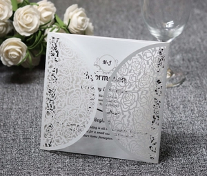 Détail de l'invitation de mariage découpée au laser avec motif de rose et couverture blanche
