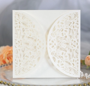 Macro detail of laser-cut ivory wedding invitation with elegant floral hollow patterns