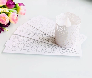 Laser-cut white paper candle wraps with elegant hollow rose patterns for LED tea lights