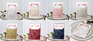 Macro shot of laser cut burgundy wedding invitations with delicate floral inner cards